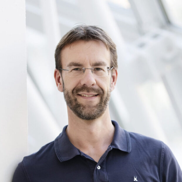 Berater für Photovoltaikanlagen in Köln vor modernem Gebäude.